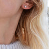 Woman wearing a Birthstone Stud Earring featuring a 4 mm briolette cut Moonstone bezel set in 14k white gold