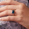 Woman's hand wearing a 14k yellow gold Warren Horizontal Atlantic Blue Topaz Ring with Diamonds, showcasing an 8 x 10mm Atlantic Blue Topaz and 16 prong-set diamonds.