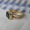 Side view of a Warren Horizontal Atlantic Blue Topaz Ring with Diamonds, featuring an 8 x 10mm Atlantic Blue Topaz and 16 prong-set diamonds in 14k yellow gold.