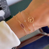 Woman wearing multiple bracelets including an Adelaide Mini bracelet featuring one 1/2” cutout Peace Sign in 14k gold