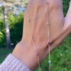 Woman holding a Pink Awareness Bayberry necklace featuring eleven 4 mm pink tourmalines & moonstones bezel set in 14k gold