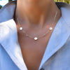 Woman with a 14k gold Classic necklace featuring two birthstones & three 1/4” flat letter-engraved discs