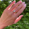 Woman wearing a Greenwich ring featuring four 4 mm round white topaz and one 2.1 mm diamond prong set in 14k yellow gold
