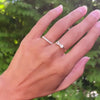 Hand with two rings including a Greenwich ring featuring two 4 mm gemstones and one 2.1 mm diamond prong set in 14k gold