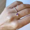Woman wearing two rings including a Greenwich ring featuring one 4 mm amethyst and one 2.1 mm diamond prong set in 14k gold