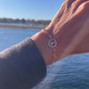 Woman's hand with a Newport bracelet featuring one 1/2” cutout Peace Sign and 4 mm gemstones bezel set in 14k yellow gold