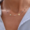 Woman with a 14k yellow gold Classic necklace featuring four birthstones and four 1/4” flat letter-engraved discs