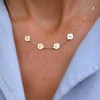 Woman with a 14k yellow gold cable chain necklace featuring four 1/4” flat discs engraved with the letters LUCY