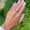 Female hand with a Rosecliff stackable ring featuring eleven 2 mm faceted round cut amethysts prong set in 14k yellow gold