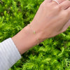 Woman's hand with a Bayberry Grand & Classic cable chain bracelet in 14k gold featuring alternating 4 mm and 6 mm peridots