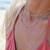 Woman with two Newport necklaces featuring 4 mm briolette cut gemstones bezel set in 14k yellow gold
