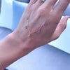 A woman's hand holding a Providence 5 Amethyst drop necklace featuring 5 petite baguette stones set in 14k yellow gold