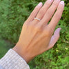 Hand wearing a Rosecliff stackable ring featuring alternating 2mm Nantucket blue topaz and diamonds prong set in 14k gold