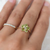 Woman wearing two rings including a Greenwich ring featuring five 4 mm peridots and one 2.1 mm diamond prong set in 14k gold
