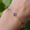 Woman with a Grand & Classic bracelet featuring one 6 mm and four 4 mm Amethysts bezel set in 14k yellow gold