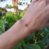 Woman wearing a Grand & Classic bracelet featuring one 6 mm and four 4 mm Amethysts bezel set in 14k yellow gold
