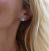 Woman wearing a 14k gold Greenwich 5 Birthstone earring featuring five 4 mm Nantucket blue topaz and one 2.1 mm diamond