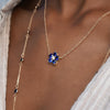 Woman with two 14k gold necklaces including a Greenwich necklace featuring five 4 mm round cut sapphires & one 2.1 mm diamond