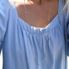 Woman wearing a Bayberry Birthstone Wrap necklace featuring 4 mm briolette cut moonstones bezel set in 14k gold