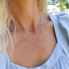 Woman wearing a Bayberry Birthstone Wrap necklace featuring 4 mm briolette cut citrines bezel set in 14k yellow gold