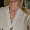 Woman wearing a Rosecliff Heart Necklace featuring twenty faceted round cut Nantucket blue topaz prong set in 14k Gold