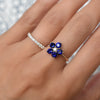 Woman wearing two rings including a Greenwich ring featuring five 4 mm sapphires and one 2.1 mm diamond prong set in 14k gold