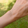 Woman wearing a Classic cable chain bracelet featuring one 4 mm briolette cut citrine bezel set in 14k yellow gold