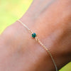 Wrist with Classic cable chain bracelet featuring one 4 mm briolette cut emerald bezel set in 14k yellow gold