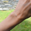 Woman with a Classic cable chain bracelet featuring one 4 mm briolette cut moonstone bezel set in 14k yellow gold