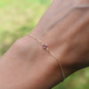 Woman with a Classic cable chain bracelet featuring one 4 mm briolette cut pink tourmaline bezel set in 14k yellow gold