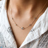 Woman wearing a Grand & Classic 14k gold 1.17 mm cable chain necklace featuring four 4 mm & one 6 mm briolette cut gemstones