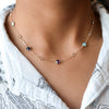 Woman with a Grand & Classic 14k gold 1.17 mm cable chain necklace featuring eight 4 mm and eight 6 mm bezel set gemstones
