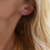 Woman wearing a 14k yellow gold Greenwich 5 Birthstone earring featuring five 4 mm amethysts and one 2.1 mm diamond