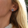 Woman wearing a 14k yellow gold Greenwich 5 Birthstone earring featuring five 4 mm alexandrites and one 2.1 mm diamond