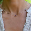 Woman wearing a Bayberry Grand & Classic 14k gold necklace featuring alternating 4 mm & 6 mm briolette cut bezel set garnets