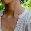 Woman wearing a Bayberry Grand & Classic 14k gold necklace featuring eleven alternating 4 mm & 6 mm briolette cut amethysts