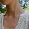 Woman wearing a Bayberry Grand & Classic 14k gold necklace featuring alternating 4 mm & 6 mm briolette cut bezel set peridots