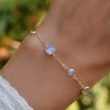 Woman with a Bayberry Grand & Classic 1.17 mm cable chain bracelet in 14k gold featuring alternating 4 mm and 6 mm moonstones