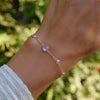 Hand with a Bayberry Grand & Classic 1.17 mm cable chain bracelet in 14k gold featuring alternating 4 mm and 6 mm moonstones
