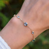 Woman with a Bayberry Grand & Classic cable chain bracelet in 14k gold featuring alternating 4 mm & 6 mm Nantucket blue topaz