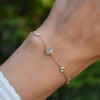 Woman wearing a Bayberry Grand & Classic cable chain bracelet in 14k gold featuring alternating 4 mm and 6 mm white topaz