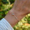 Hand wearing a Bayberry Grand & Classic cable chain bracelet in 14k gold featuring alternating 4 mm and 6 mm white topaz