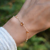 Hand with a Bayberry Grand & Classic cable chain bracelet in 14k gold featuring seven alternating 4 mm and 6 mm citrines