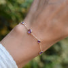 Hand with a Bayberry Grand & Classic 1.17 mm cable chain bracelet in 14k gold featuring 7 alternating 4 mm & 6 mm amethysts