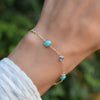 Woman with a gold Bayberry Grand & Classic cable chain bracelet with 4 mm Nantucket blue topaz & 6 mm turquoise gemstones