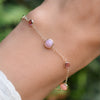 Hand with a Bayberry Grand & Classic cable chain bracelet in 14k gold featuring 4 mm pink tourmalines & 6 mm pink opals
