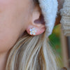 Woman wearing a 14k yellow gold Greenwich 5 Birthstone earring featuring five 4 mm opals and one 2.1 mm diamond