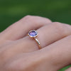 Woman's hand wearing a 1.6 mm wide 14k yellow gold Grand ring featuring one 6 mm briolette cut bezel set amethyst