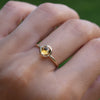 Woman's hand wearing a 1.6 mm wide 14k yellow gold Grand ring featuring one 6 mm briolette cut bezel set citrine