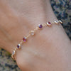 Woman wearing a De-Lovely Newport 14k gold bracelet featuring alternating 4 mm pink tourmalines, moonstones & amethysts